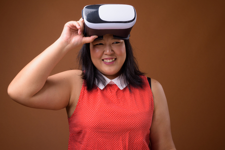 Portrait of happy Asian woman holding virtual reality VR glassesの写真素材