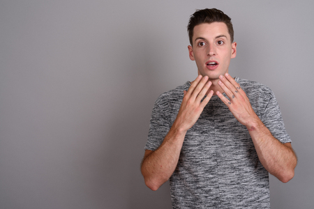 Young handsome man looking shocked and surprisedの写真素材