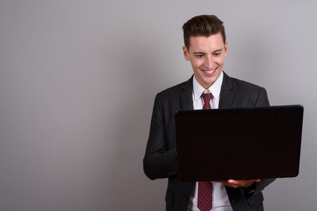 Happy businessman smiling and using laptop computerの写真素材