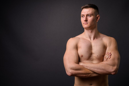 Handsome muscular fitness man shirtless with arms crossed thinkingの写真素材