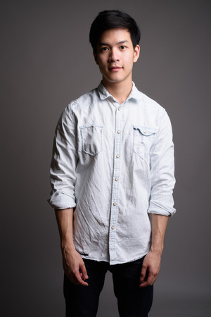 Studio portrait of young handsome Asian businessmanの写真素材