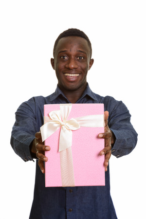 Young happy African man smiling and giving gift boxの写真素材