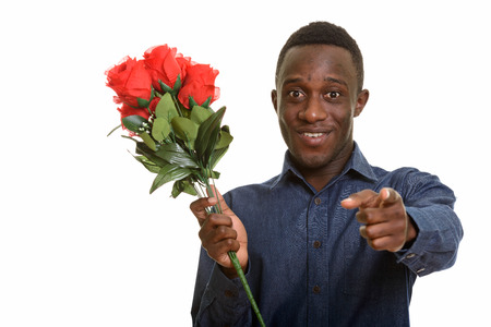 Young happy African man smiling and pointing finger while holdinの写真素材