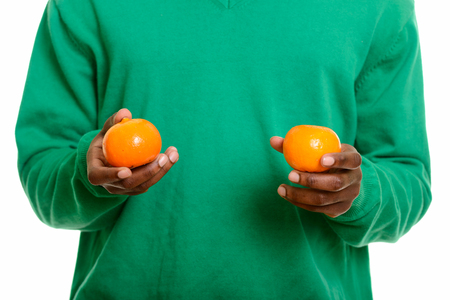 Young African man hands holding two orangesの写真素材