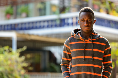 Portrait of young African man outdoors wearing hoodieの写真素材