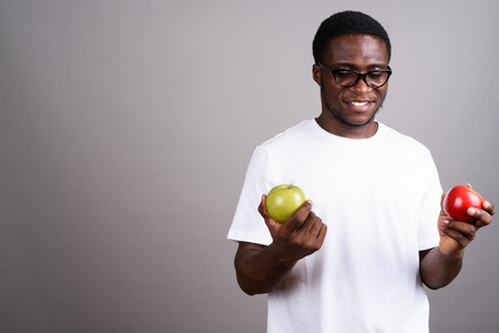 Young African man wearing white shirt and eyeglasses against graの写真素材