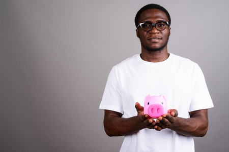 Young African man wearing white shirt and eyeglasses against graの写真素材