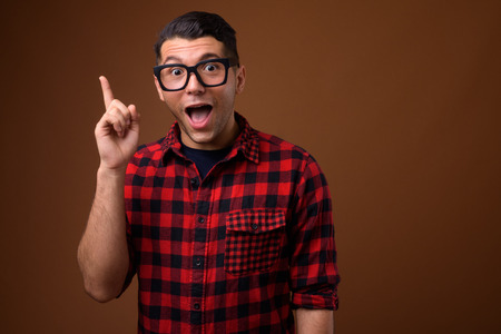 Portrait of young handsome man against brown background
