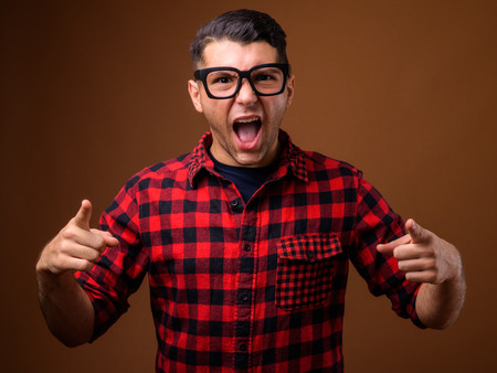 Portrait of young handsome man against brown backgroundの写真素材