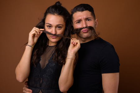 Young couple together and in love against brown background