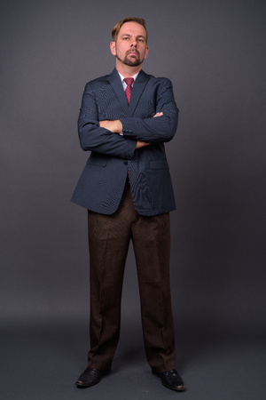 Blond bearded businessman with goatee against gray backgroundの写真素材