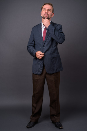 Blond bearded businessman with goatee against gray backgroundの写真素材