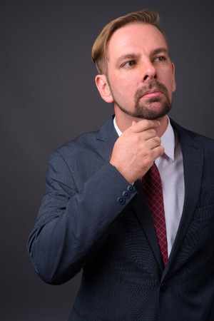 Blond bearded businessman with goatee against gray backgroundの写真素材