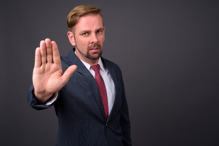 Blond bearded businessman with goatee against gray backgroundの写真素材