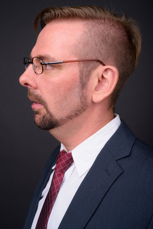 Blond bearded businessman with goatee against gray backgroundの写真素材