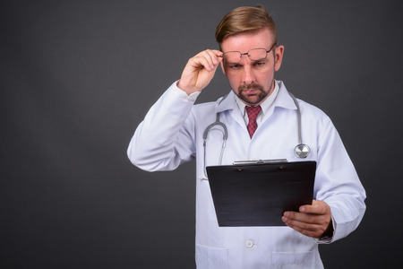 Blond bearded man doctor with goatee against gray backgroundの写真素材
