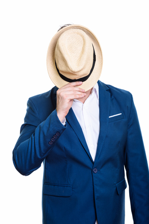 Studio shot of mature businessman covering face with hatの写真素材