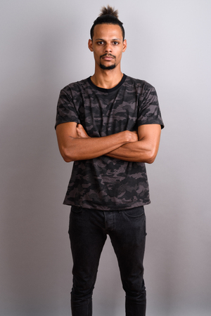 Young bearded handsome African man against gray backgroundの写真素材