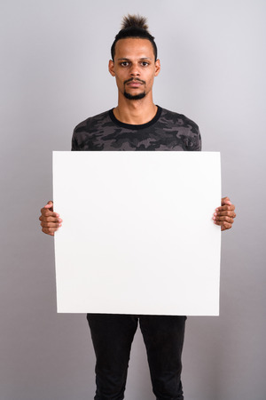 Young bearded handsome African man against gray backgroundの写真素材
