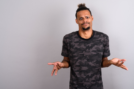 Young bearded handsome African man against gray backgroundの写真素材