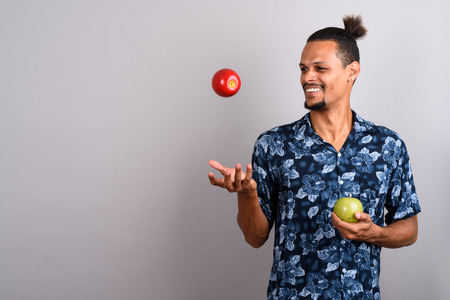 Young bearded handsome African man against gray backgroundの写真素材