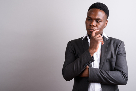 Young African businessman wearing suit against white backgroundの写真素材
