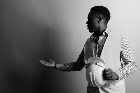 Young African man construction worker showing something in blackの写真素材