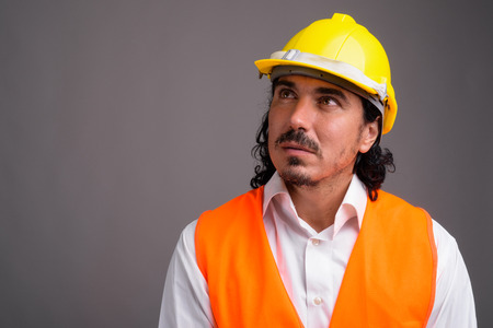 Handsome man construction worker with mustache against gray back