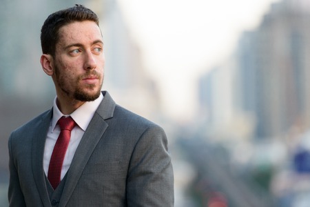 Young businessman thinking at rooftop in cityの写真素材