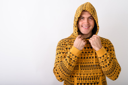 Studio shot of young happy muscular man smiling and holding hood
