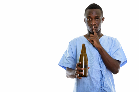 Studio shot of young black African man patient holding bottle ofの写真素材