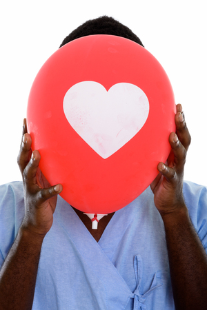 Face of young black African man patient hiding face behind red bの写真素材