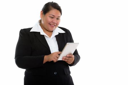 Studio shot of young happy fat Asian businesswoman smiling whileの写真素材