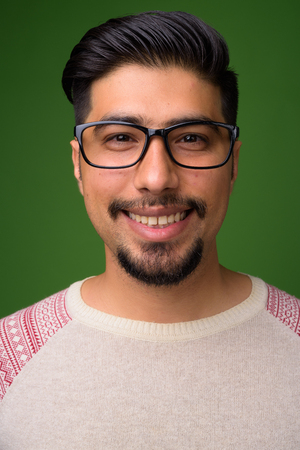 Young bearded Iranian man against green backgroundの写真素材