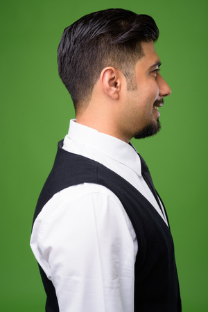 Young bearded Iranian businessman against green backgroundの写真素材