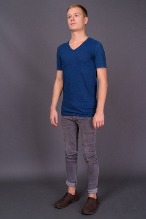 Portrait of young handsome man against gray backgroundの写真素材