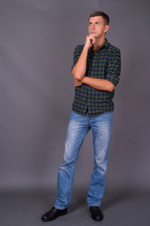 Handsome man with short hair against gray backgroundの写真素材