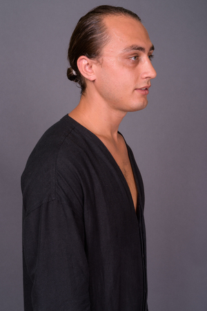 Portrait of young handsome man against gray backgroundの写真素材