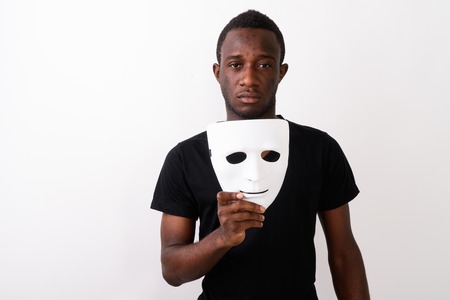 Studio shot of young black African man holding maskの写真素材