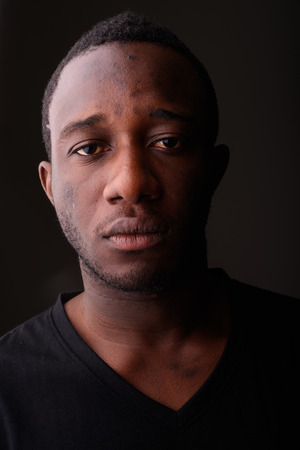 Portrait of young black African man in dark roomの写真素材