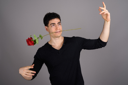 Portrait of young handsome man against gray backgroundの写真素材