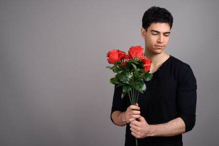 Portrait of young handsome man against gray backgroundの写真素材