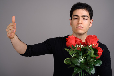 Portrait of young handsome man against gray backgroundの写真素材