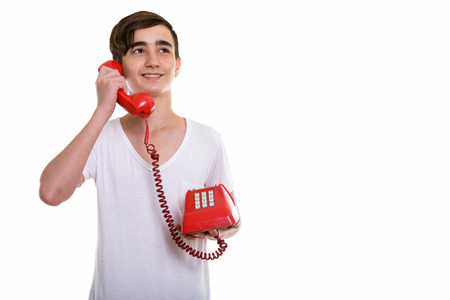 Studio shot of young happy Persian teenage boy smiling and thinkingの写真素材
