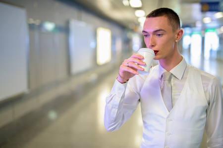 Young androgynous homosexual LGTB businessman drinking coffeeの写真素材