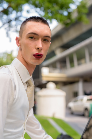 Young androgynous homosexual LGTB businessman wearing lipstickの写真素材