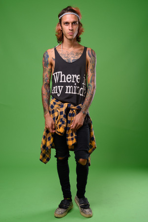 Studio shot of rebellious young man against green backgroundの写真素材