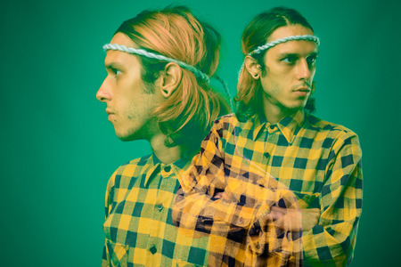 Studio shot of rebellious young man against green background