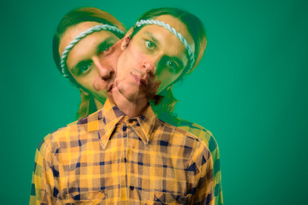 Studio shot of rebellious young man against green background