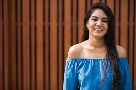 Portrait of young happy Indian woman smiling outdoorsの写真素材
